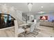 Elegant dining room with a glass table, seating for six, modern lighting, and seamless flow to living spaces at 8515 Morehouse Dr, Orlando, FL 32836