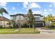 Elegant two-story home with a manicured lawn, paver driveway, tile roof, and a beautiful architectural design at 8515 Morehouse Dr, Orlando, FL 32836