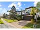 Attractive two-story home with a tile roof, paver driveway, mature trees, and a spacious two car garage at 8515 Morehouse Dr, Orlando, FL 32836