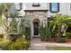 Inviting front entrance with a stone archway, a dark wood door, and lush landscaping with colorful flowers at 8515 Morehouse Dr, Orlando, FL 32836