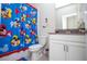 Bright bathroom featuring a Mickey Mouse themed shower curtain and modern white vanity at 8988 Cabot Cliffs Dr, Champions Gate, FL 33896