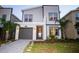 Attractive two-story home featuring a modern color palette and well-manicured landscaping at 8988 Cabot Cliffs Dr, Champions Gate, FL 33896