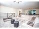 Spacious living room with large couch, chandelier, and dark metal railing at 8988 Cabot Cliffs Dr, Champions Gate, FL 33896