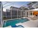 Backyard pool with a screened-in enclosure at 8988 Cabot Cliffs Dr, Champions Gate, FL 33896