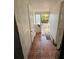 Hallway with damaged walls leading to the backyard view at 9350 2Nd Ave, Orlando, FL 32824