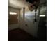 Room with exposed walls, damaged plaster, and view through door and window at 9350 2Nd Ave, Orlando, FL 32824