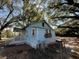 Side of a home featuring an entry porch, surrounded by mature trees and fencing at 9350 2Nd Ave, Orlando, FL 32824