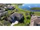 Breathtaking aerial view of the home with a serene lake backdrop surrounded by lush greenery and mature trees at 9526 Lake Hugh Dr, Gotha, FL 34734