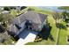 Stunning aerial view of the estate featuring a manicured lawn, elegant driveway, and beautifully designed landscaping at 9526 Lake Hugh Dr, Gotha, FL 34734