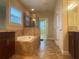 Bright bathroom features a soaking tub with tiled surround and glass-enclosed shower at 9526 Lake Hugh Dr, Gotha, FL 34734
