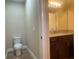 Powder room featuring a toilet, a sink with dark wood cabinets and granite countertops at 9526 Lake Hugh Dr, Gotha, FL 34734