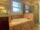 Bathroom featuring a tiled tub, shower, granite counters and window at 9526 Lake Hugh Dr, Gotha, FL 34734