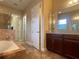 The bathroom features a tub, shower, tile floors and granite countertop at 9526 Lake Hugh Dr, Gotha, FL 34734