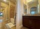 Bathroom featuring vanity with granite countertop, and a shower with tan tiling at 9526 Lake Hugh Dr, Gotha, FL 34734