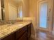 Bathroom featuring a sink with granite countertops and a door leading to the outside at 9526 Lake Hugh Dr, Gotha, FL 34734