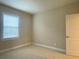 Bright bedroom with neutral walls, a window with blinds, and a white door at 9526 Lake Hugh Dr, Gotha, FL 34734