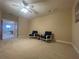 Spacious bonus room with neutral carpet, ceiling fan, and sitting area featuring two chairs at 9526 Lake Hugh Dr, Gotha, FL 34734