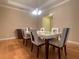Formal dining room featuring a modern table and chairs, complemented by hardwood flooring at 9526 Lake Hugh Dr, Gotha, FL 34734