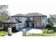 Elegant two-story stucco home featuring a three-car garage, stone accents, and well-manicured landscaping at 9526 Lake Hugh Dr, Gotha, FL 34734