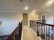 Hallway with decorative wrought iron spindles and neutral colored walls at 9526 Lake Hugh Dr, Gotha, FL 34734