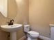 Compact powder room with pedestal sink, toilet, and neutral wall color at 9526 Lake Hugh Dr, Gotha, FL 34734