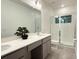 Bright bathroom featuring a large mirror, gray cabinets, and a glass enclosed shower at 10437 Ebb Tide Ln, Orlando, FL 32821