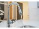 Modern kitchen features a stainless steel gooseneck faucet with water running in a light and bright space at 10437 Ebb Tide Ln, Orlando, FL 32821