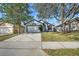 Charming one-story home with mature trees, well-manicured lawn, and paved driveway at 1136 Twin Rivers Blvd, Oviedo, FL 32766