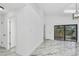 Bright living room featuring marble floors, modern lighting, and sliding glass doors to the outdoor space at 1136 Twin Rivers Blvd, Oviedo, FL 32766