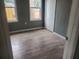 Bedroom with gray walls, wood floor, two windows and closet at 1303 37Th Nw St, Winter Haven, FL 33881