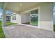 Covered patio with a stone-paved floor, showcasing an open sliding glass door for indoor-outdoor living at 13062 Sunrise Harvest Dr, Winter Garden, FL 34787