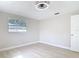 Bright bedroom with light wood floors, window, ceiling fan and a door at 1382 Wright St, Daytona Beach, FL 32117