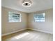 Cozy bedroom features light wood floors, two windows, and a modern ceiling fan at 1382 Wright St, Daytona Beach, FL 32117