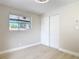 This bedroom features wood-look floors, a window, and closet with white bi-fold doors at 1382 Wright St, Daytona Beach, FL 32117