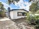 Charming single-story home featuring a gray chimney, large windows, and neutral-colored exterior siding at 1382 Wright St, Daytona Beach, FL 32117