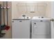 Functional laundry room with modern Maytag washer and dryer, complete with storage shelves at 1619 Leatherback Ln, St Cloud, FL 34771