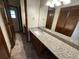 Bathroom featuring granite countertops, a large mirror, and tile flooring at 1811 Springwood Ln, Deltona, FL 32725