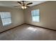 Carpeted bedroom featuring two bright windows and ceiling fan at 1811 Springwood Ln, Deltona, FL 32725