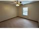 Bedroom featuring neutral-colored walls and carpet, a ceiling fan, and a window at 1811 Springwood Ln, Deltona, FL 32725