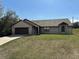 Charming single-story brick home featuring an attached two-car garage and well-maintained front lawn at 1811 Springwood Ln, Deltona, FL 32725