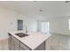 Bright open-concept kitchen featuring stainless steel appliances, grey cabinets, and a large island with a sink at 1950 Birnham Wood Bnd, Kissimmee, FL 34746