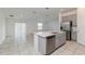 Bright open-concept kitchen featuring stainless steel appliances, grey cabinets, and a large island with a sink at 1950 Birnham Wood Bnd, Kissimmee, FL 34746