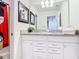 Bright bathroom boasts double sinks, granite countertops, and framed Mickey Mouse wall art at 201 Jetty Way, Davenport, FL 33897