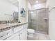 Stylish bathroom features granite countertops, a glass enclosed shower, and modern fixtures at 201 Jetty Way, Davenport, FL 33897