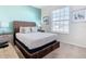 Bright bedroom with woven bed frame, neutral colors, and light blue accent wall at 201 Jetty Way, Davenport, FL 33897