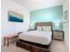 Comfortable bedroom with cool blue accent wall, television, and woven-style furniture at 201 Jetty Way, Davenport, FL 33897