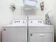 Functional laundry room equipped with a washer, dryer, shelving, and other essentials at 201 Jetty Way, Davenport, FL 33897