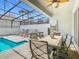 Covered outdoor dining area adjacent to the refreshing private pool and sundeck at 201 Jetty Way, Davenport, FL 33897