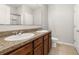 Bathroom with dual sinks, wood cabinets and neutral countertops at 209 Arbor Lakes Dr, Davenport, FL 33896