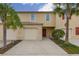 Inviting townhome showcasing a vibrant red door, desert landscaping and a charming exterior design at 209 Arbor Lakes Dr, Davenport, FL 33896
